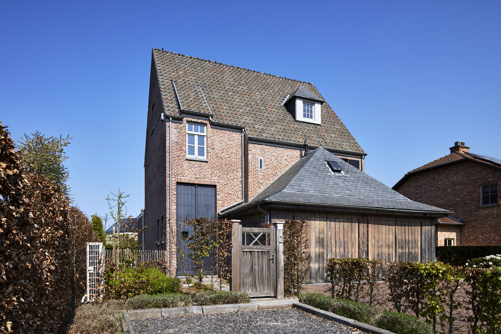 JOLIE Türbeschläge in einem modernen Landhaus-Interieur — Holztür mit Bronze-Griff, Naturstein-Boden